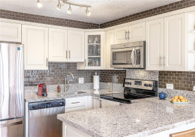 Tastefully upgraded kitchen with stainless steel appliances and quartz countertops.
